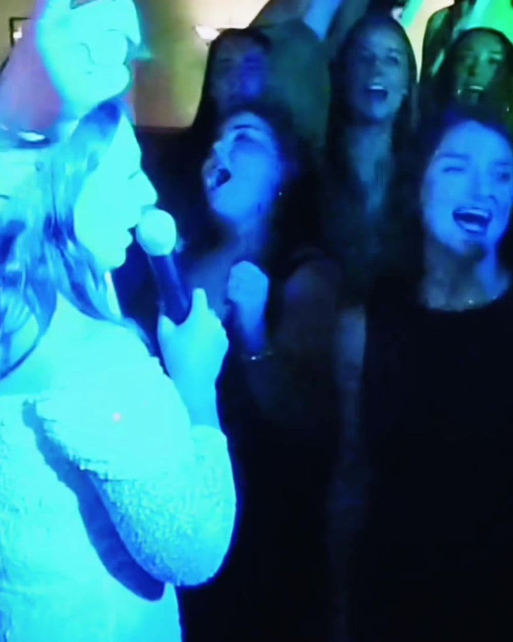 Hen party singing along on the mic with glowsticks