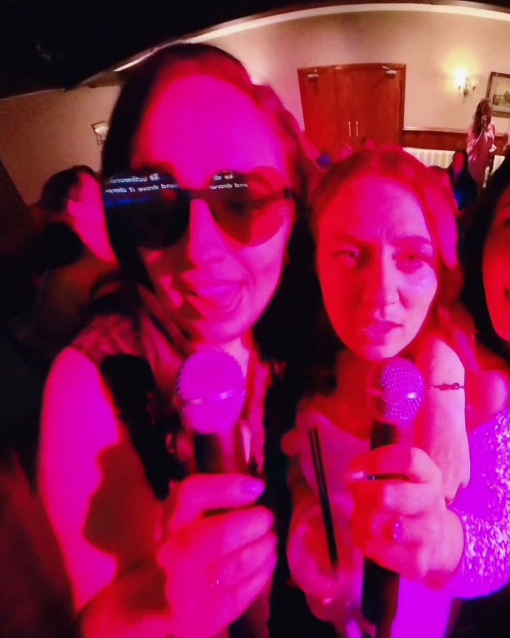 Hen party guests singing karaoke together