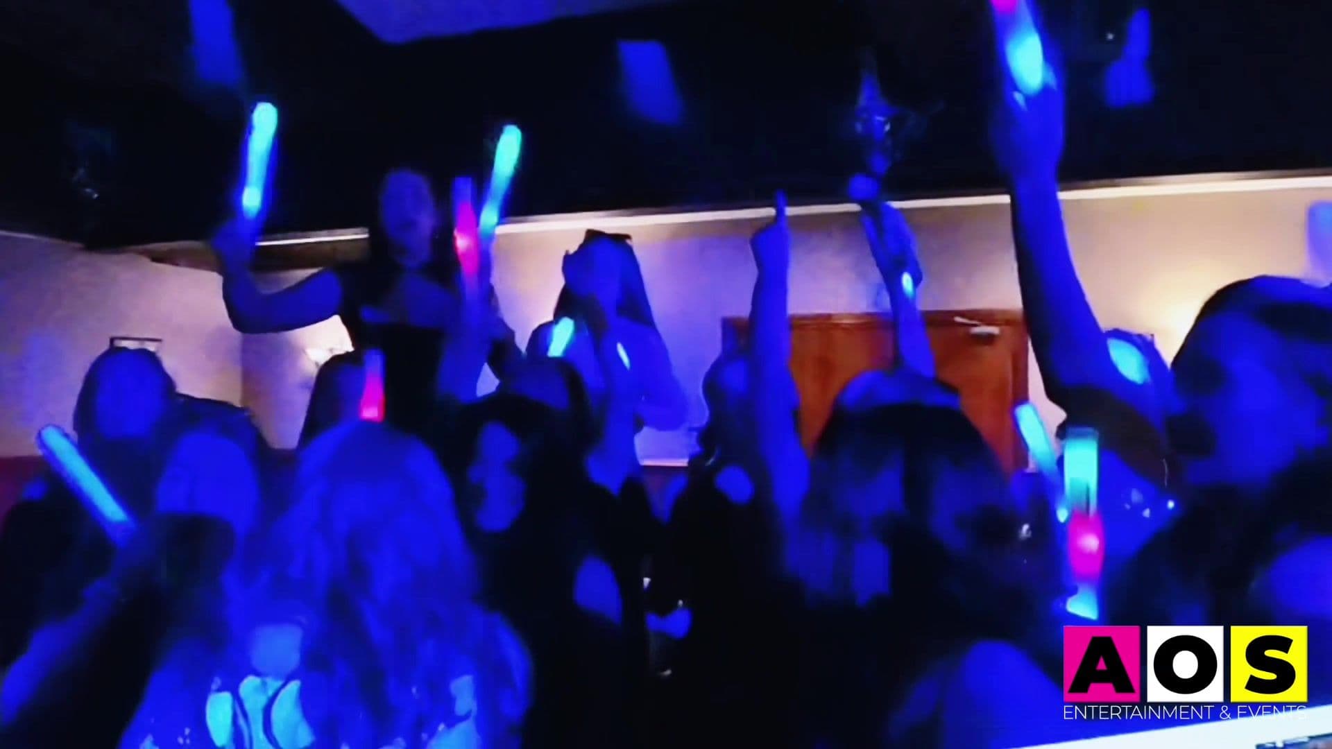 Hen party guests waving glowsticks with DJ Alan