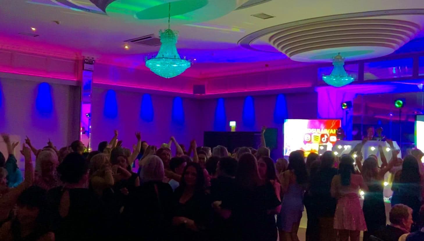 Packed dancefloor with screens and lighting at a Cork function